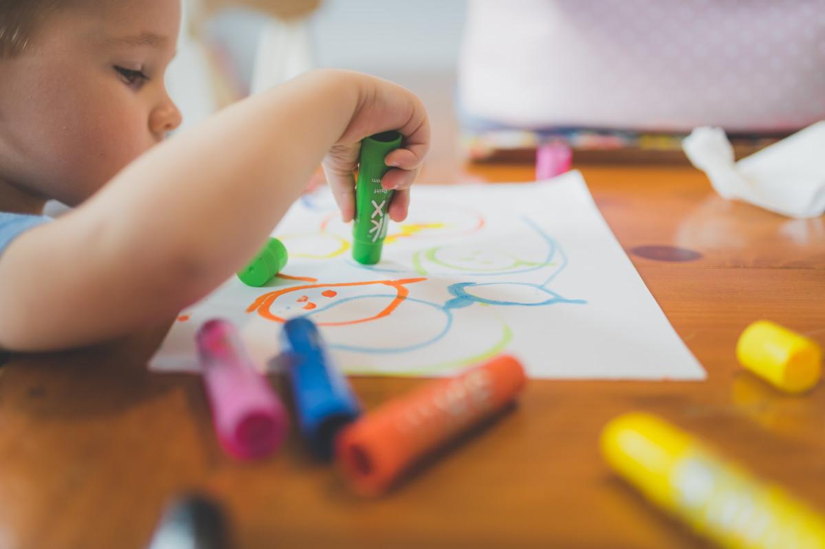 child coloring with paint sticks