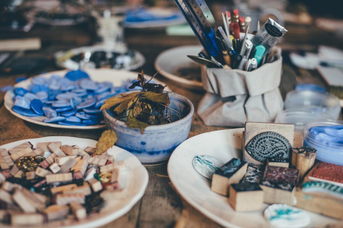 image of paintbrushes, stamps, and dried leaves